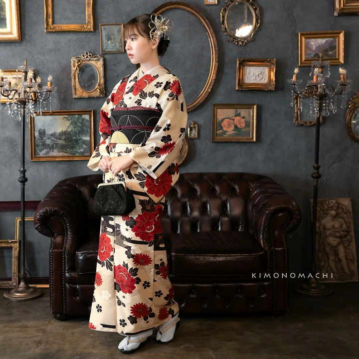 Femme portant un kimono beige &agrave; grands motifs floraux rouges et noirs, avec un obi noir structur&eacute;, des tabi blanches et des zori, dans un d&eacute;cor int&eacute;rieur &eacute;l&eacute;gant.
