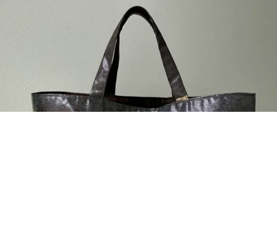 Bolso de hombro mediano con exterior met&aacute;lico y forro interior de seda en tono claro.