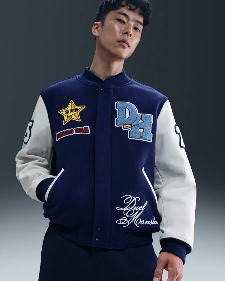 Veste Domino High issue de la collaboration Nike x Yu-Gi-Oh!, inspir&eacute;e de l&rsquo;univers de Joey Wheeler et du streetwear varsity am&eacute;ricain