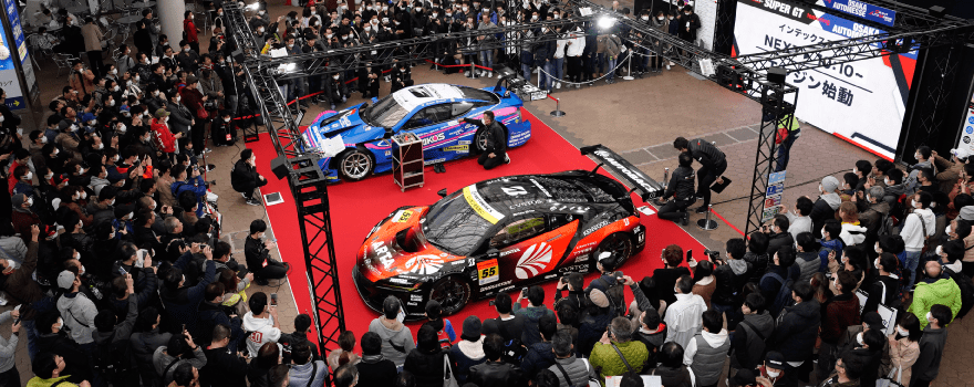 A large exhibition hall at Osaka Auto Messe, filled with modified and classic cars.