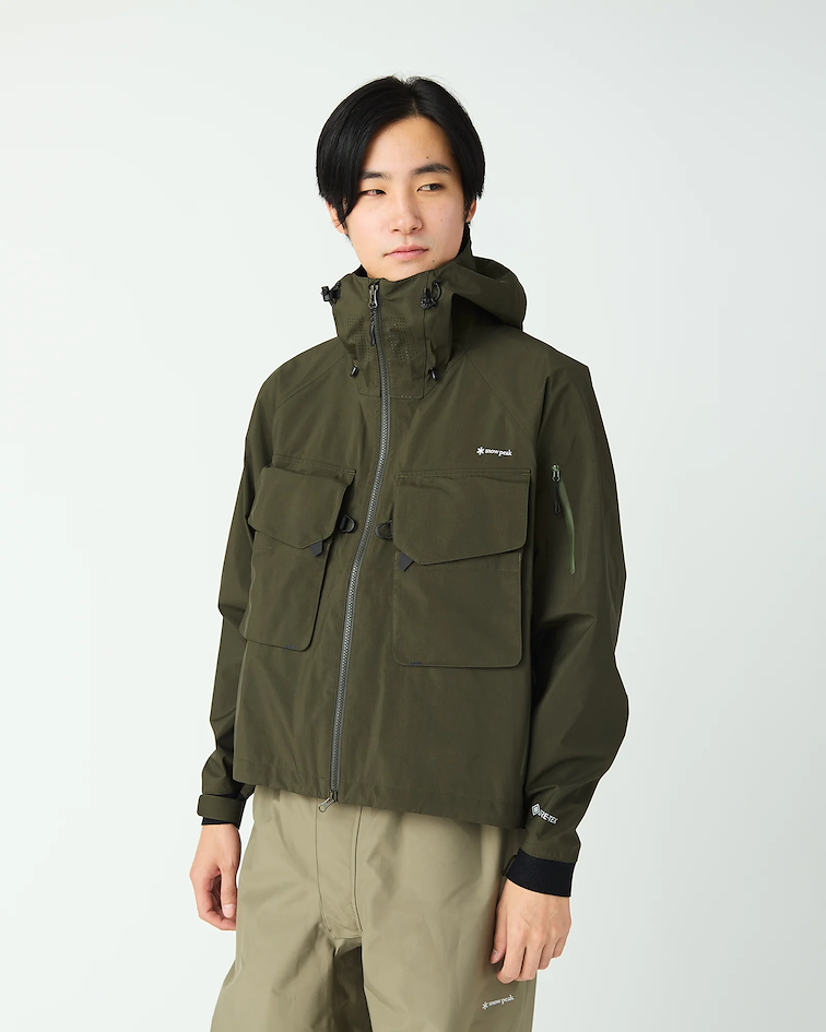 Veste technique kaki Snow Peak à capuche, coupe minimaliste et poches utilitaires, illustrant l’esthétique fonctionnelle et épurée du style gorpcore japonais.