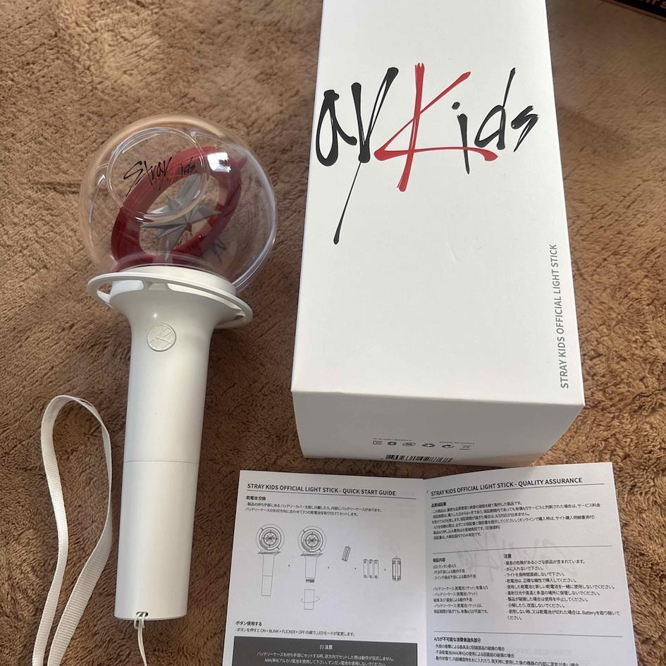 Photo d&eacute;taill&eacute;e du lightstick officiel du groupe STRAY KIDS accompagn&eacute; de son packaging et de la notice en japonais permettant de l&rsquo;authentifier.