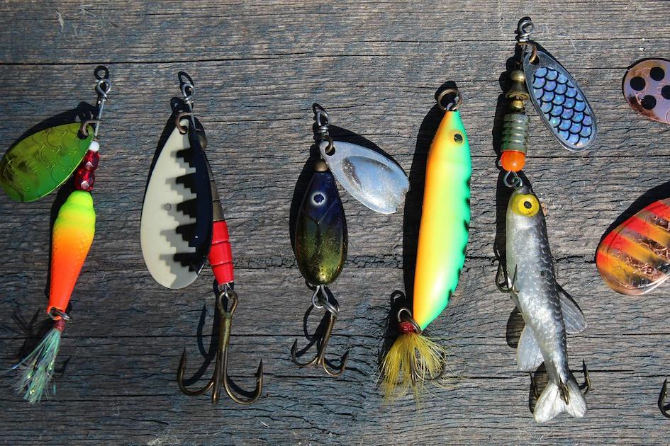 A group of fishing lures on a wood surface