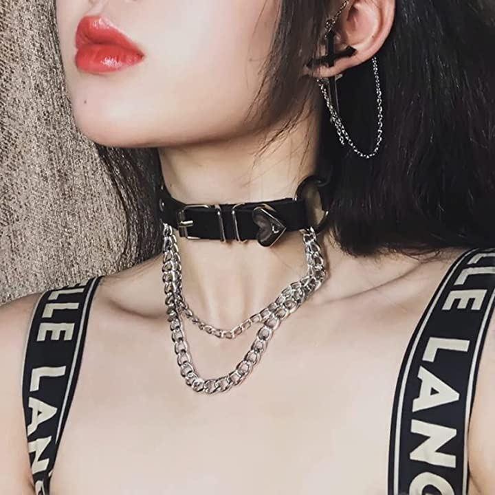 Collier ras-du-cou en cuir noir avec pendentif coeur et chaines argentées, portées dans un style inspiré du visual kei.