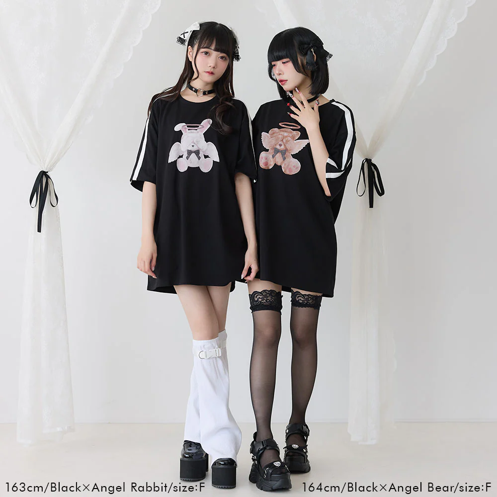 Dos jóvenes posando con camisetas oversized negras decoradas con gráficos de osos estilo Menhera. Complementan el look con medias de encaje y plataformas en un fondo minimalista blanco.