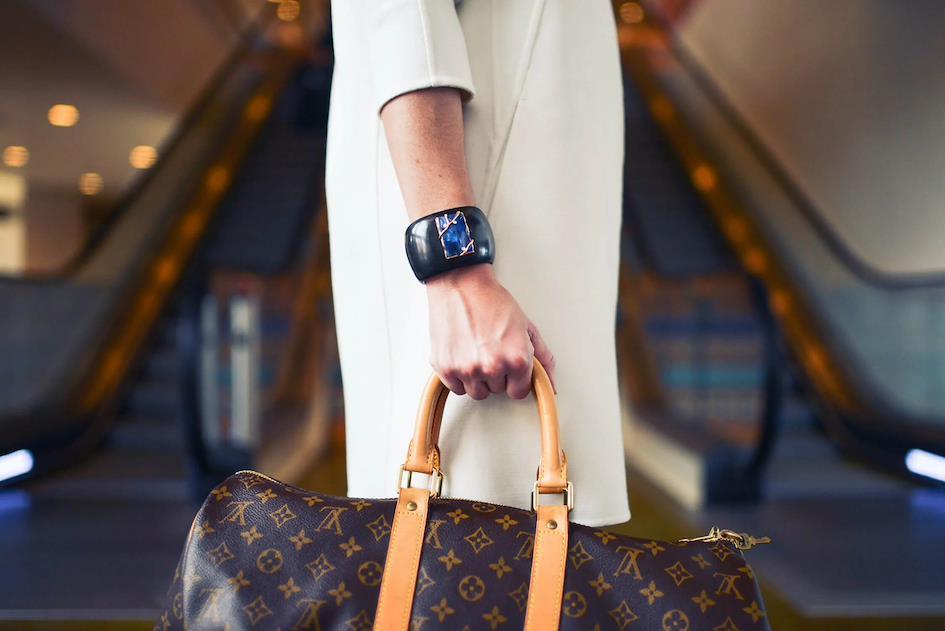 woman holding Louis Vuitton designer bag