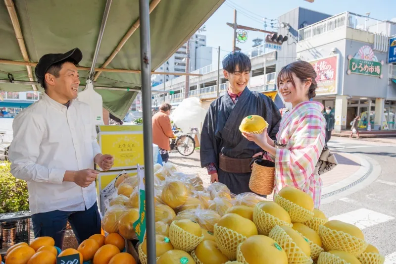 ouple en yukata achetant des fruits sur un marché japonais.