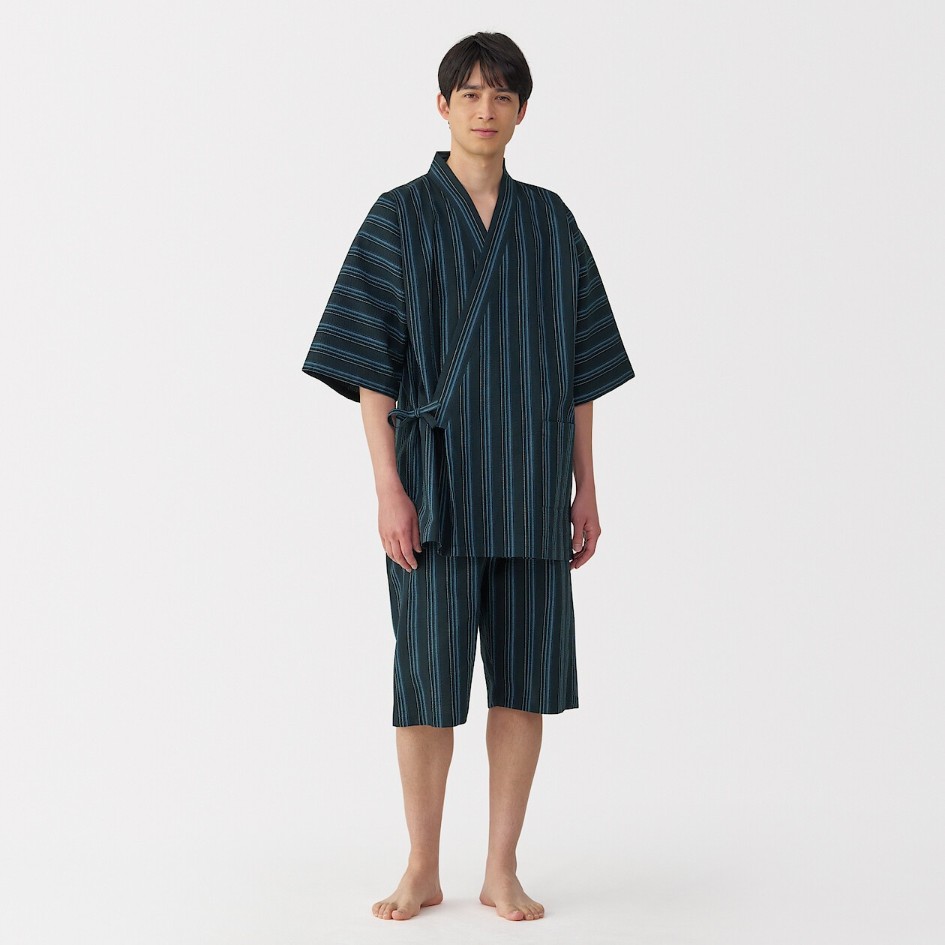 Homme portant un jinbei unisexe MUJI bleu foncé à rayures, composé d’une veste croisée à manches courtes et d’un short assorti.