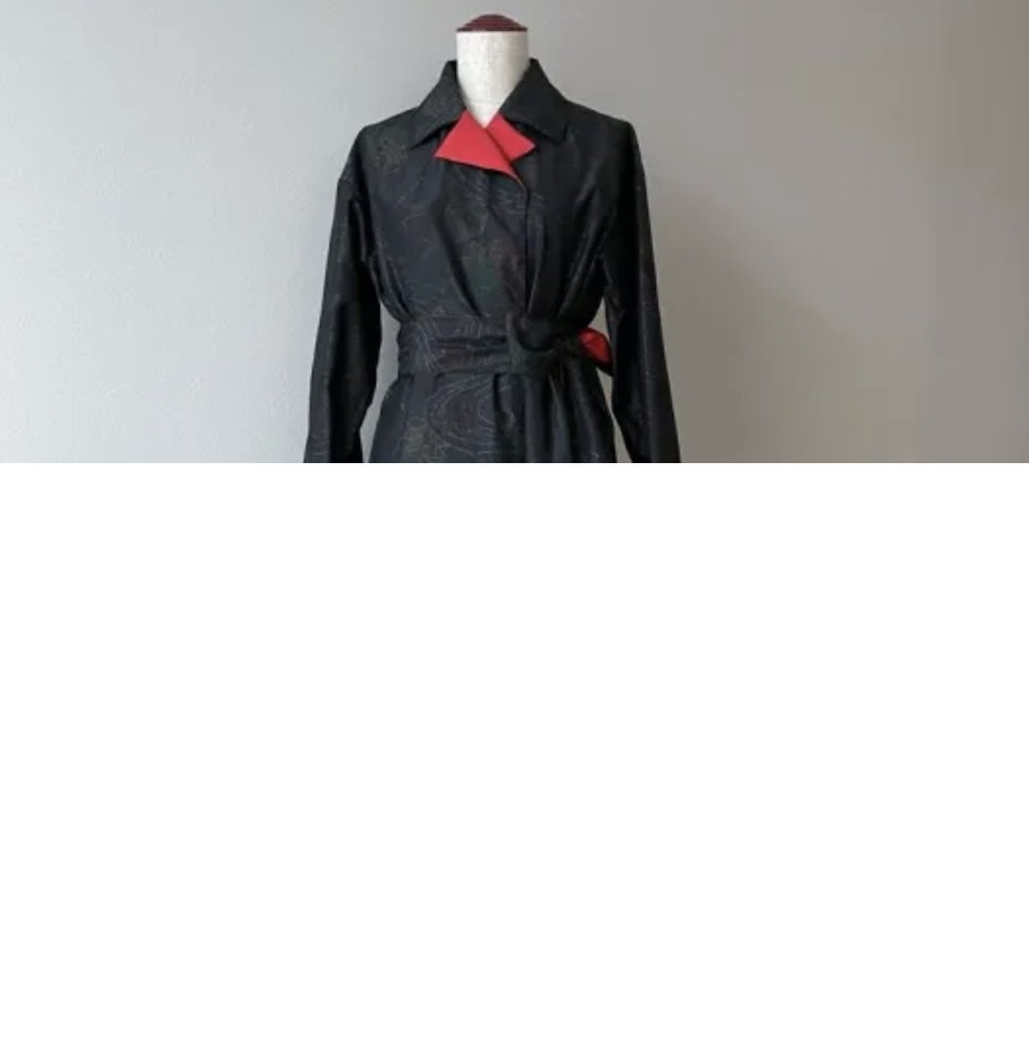 Abrigo-vestido largo en seda negra con textura rugosa, cuello forrado en rojo y dise&ntilde;o floral.