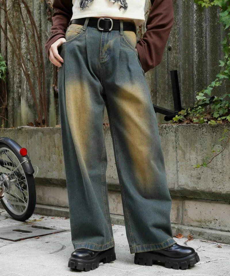 Detalle de jeans teñidos con efecto vintage, estilo grunge, combinados con botas chunky negras.